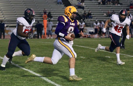 Lemoore's Donovan Lima runs for a short gain in the first quarter of the Tigers' football opener against visiting Memorial High School held Thursday night in Tiger Stadium.